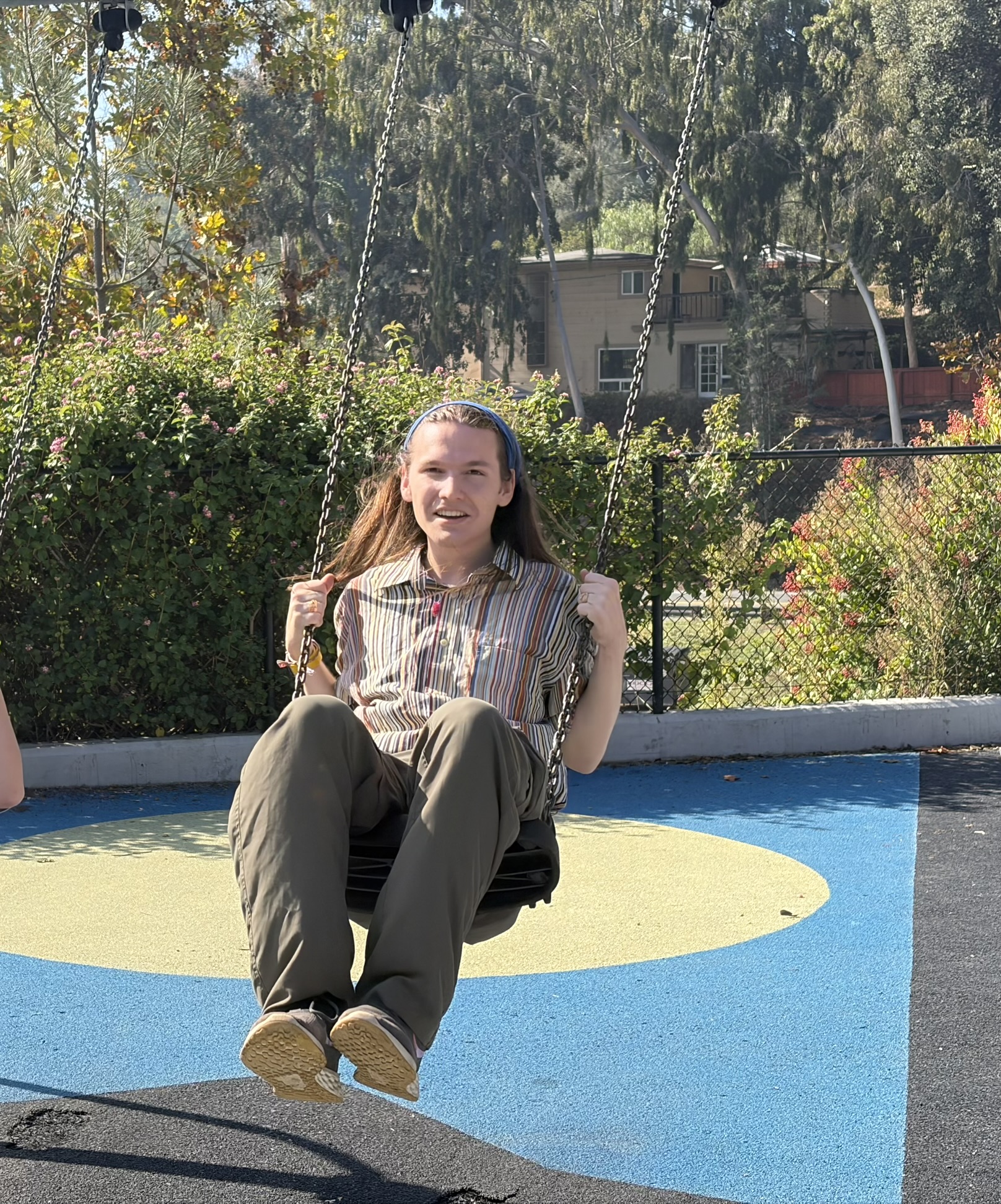 Joey smiling on a swing